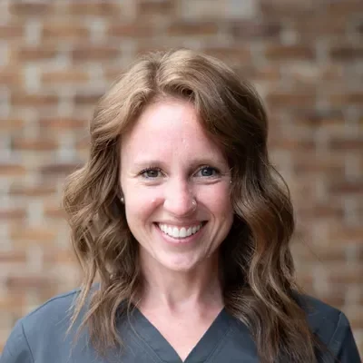 Chiropractic Wooster OH Keirstin Keirstin smiling in front of a brick wall.