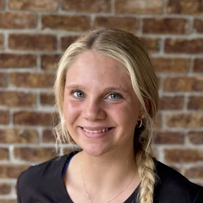 Chiropractic Wooster OH Mya Mya smiling in front of a brick wall.